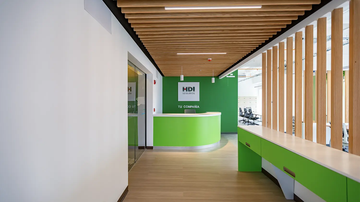 Recepción corporativa con celosía de madera en el techo, diseño de interiores por VIDCON.