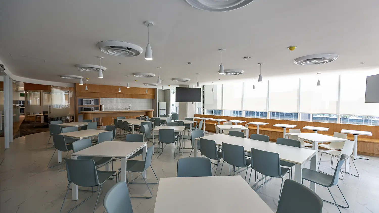 Comedor corporativo moderno en CDMX, diseño interior por VIDCON con mesas funcionales e iluminación de diseño.