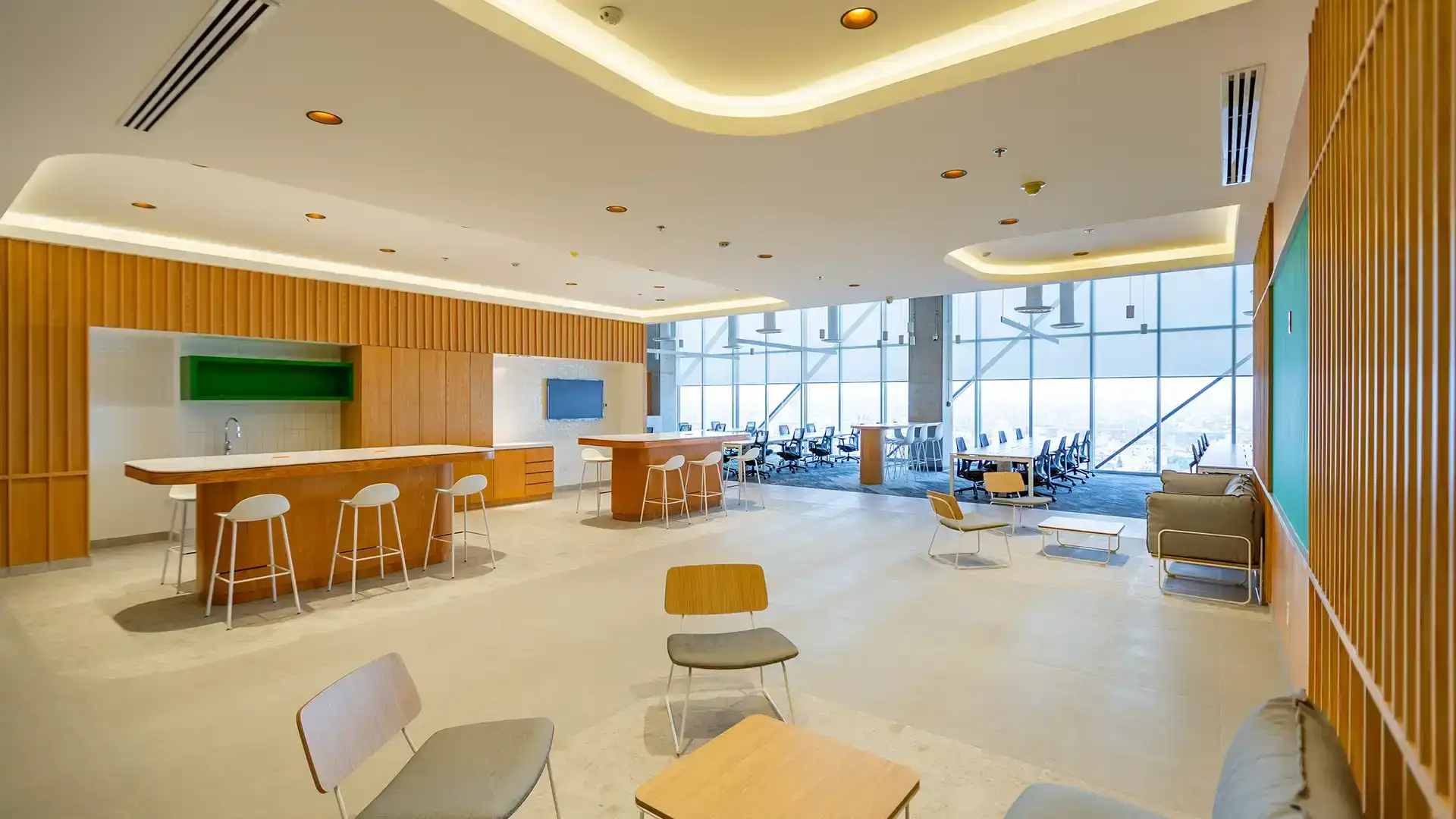 Área de convivencia abierta en CDMX, diseño funcional de VIDCON con barra de madera y vistas urbanas.